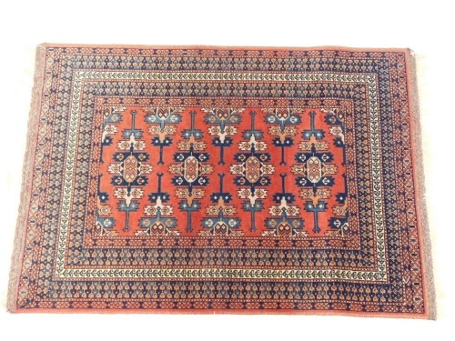 A Shiraz rug, red ground decorated with stylised field motifs and flowers, within repeating floral borders, 126cm x 88cm.