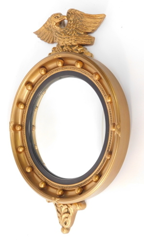 An Atsonea Regency style girandole wall mirror, with eagle mount, ebonised slip and convex glass, 60cm high.