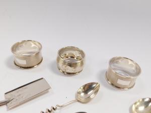 A pair of silver napkin rings, with engine turned decoration, Birmingham 1957, further napkin ring, monogram engraved, Birmingham 1901 (AF), three coffee spoons with coiled handles, salt spoon, Sheffield 1933, 2.54oz, and a Victorian silver plated trowel - 2