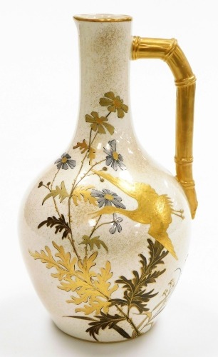 A Royal Worcester porcelain jug, on cream ground, heavily gilt decorated with storks and floral sprays and a bamboo style gilt handle, green stamp to underside, 26cm high.