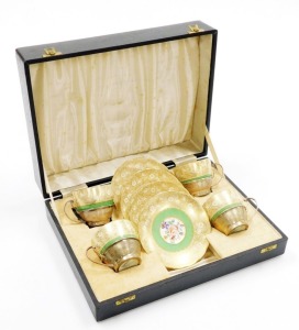 A set of four early 20thC Grosvenor China teacups and saucers, each teacup with a silver engine turned holder with marks for Birmingham 1921, in a fitted case.