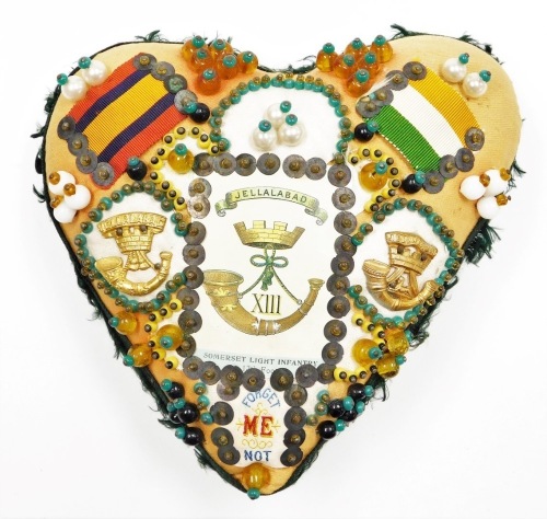 A forget me not heart shaped sweetheart pin cushion, with applied beaded detailing and Jellalabad trumpet emblem and badges, 16cm high, 19cm wide.