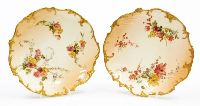 A pair of Royal Worcester blush ivory porcelain cabinet plates, decorated with flowers, etc., within a gilt shaped border, stamped to underside 237812, 21cm diameter.