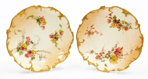 A pair of Royal Worcester blush ivory porcelain cabinet plates, decorated with flowers, etc., within a gilt shaped border, stamped to underside 237812, 21cm diameter.