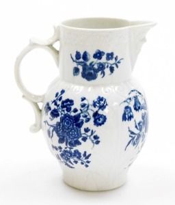 An 18thC first period Worcester porcelain jug, with mask head spout, in the three flowers pattern, with blue and white with crescent mark to underside, 14.5cm high.
