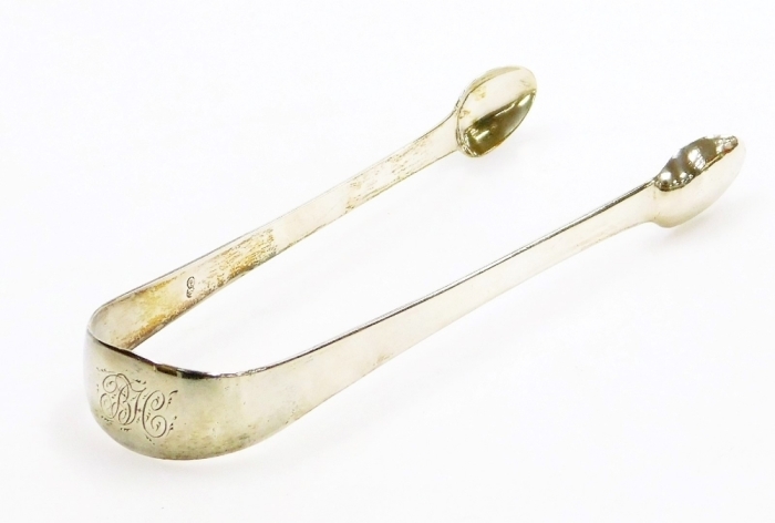 A pair of George III silver sugar tongs, of plain design with engraved H.C? monogram, London 1819, 1oz, 15cm long.