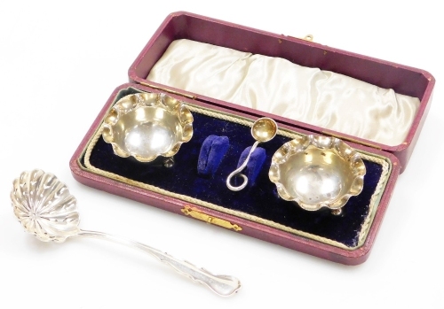 A 19thC silver sifter spoon, with a pierced bowl and shaped handle, hallmarks rubbed, marks for London, 12cm long, and a pair of Edward VII open salts, with a flared rim on three ball feet, Birmingham 1905, and a single silver plated salt spoon (1 missing