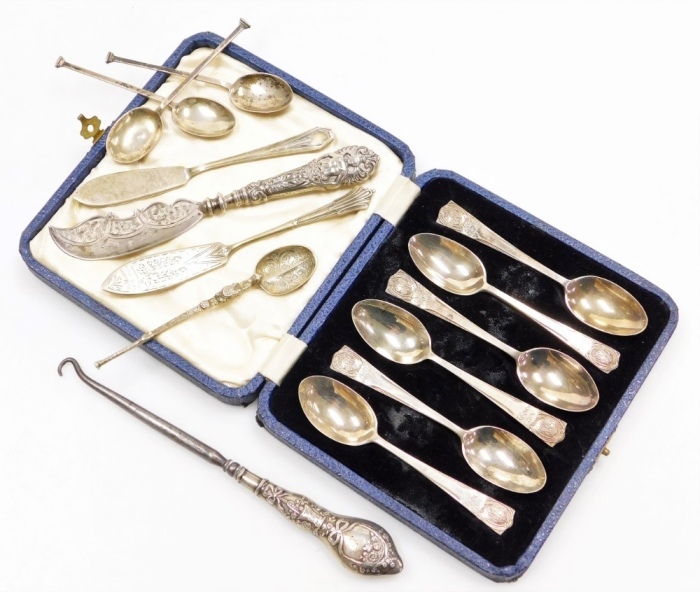 A collection of small silver, to include a set of six George V silver commemorative teaspoons, in a fitted box, London 1935, a silver handled button hook, a silver butter knife, the blade with engraved decoration and the handle profusely decorated with a 
