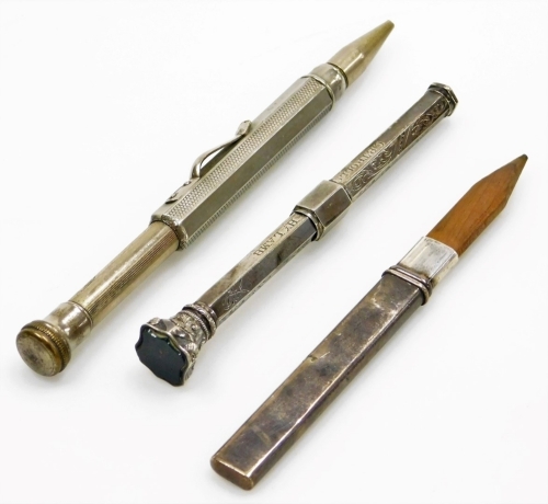 A collection of small silver and silver plated writing instruments, to include a silver pencil holder of plain design, hallmarks rubbed, a silver plated propelling pencil, the top inset with a dark green hardstone, decorated with scrolls etc., and engrave