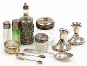 A collection of small silver, to include various glass and silver topped dressing table and scent bottles, a silver napkin ring, a pair of silver dwarf candlesticks, of plain form, Birmingham 1916, etc. (many pieces AF)