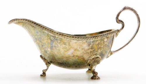 An Elizabeth II silver sauce boat, with a gadrooned border, shaped handle and three shell cast supports terminating in hoof shaped feet, makers marks for Coopers Brothers and Sons, Sheffield 1966, 4&frac34;oz, 16cm wide.
