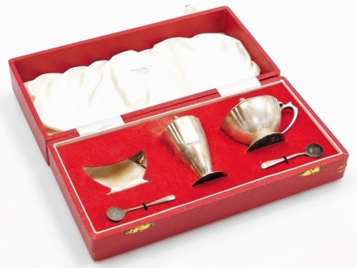 An Elizabeth II silver part cruet, the mustard pot and pepper pot with urn shaped finials and shaped bodies, London 1955, and two salt spoons, in a fitted box, 6&frac14;oz.