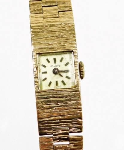 A 9ct gold Berkeley ladies wristwatch, with bark effect articulated bracelet and small square watch head, 18cm long, 23.4g all in.