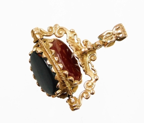 A swivel agate fob, the three point swivel with black agate blood stone and green agate, in heavy rococo detailing, in rose gold setting, yellow metal unmarked, 3cm high, 2.5cm wide, 7.1g all in.