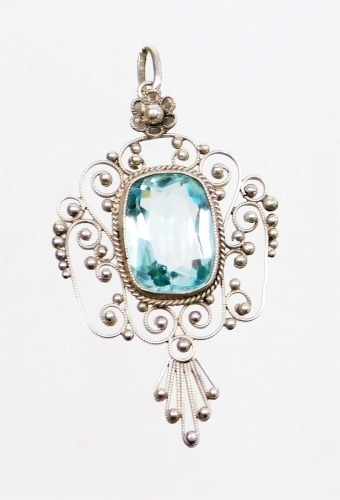 A pendant, with central blue paste stone, an outer filigree design detailing with single pendant loop, 4cm high, unmarked.
