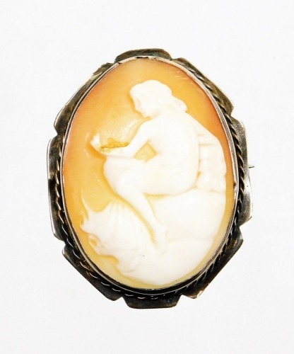 A shell cameo brooch, the oval cameo depicting figure seated on a rock, in a silvered colour outer frame, with single pin back, marked 9ct, 4.5cm x 3.5cm, 11.3g all in.