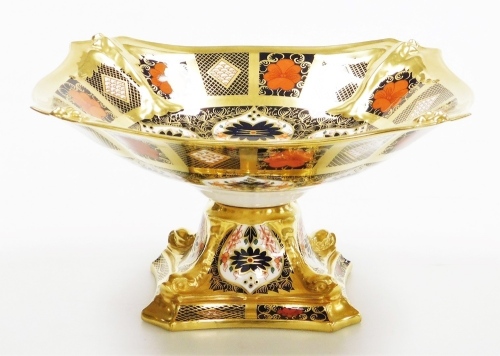 A Royal Crown Derby porcelain Imari pattern pedestal bowl, the top with a shaped border, on a square pedestal base with moulded dolphins, red stamp to underside, 26cm diameter.