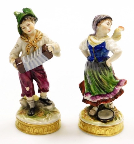 Two 19thC German porcelain figures, of a young boy with accordion and girl with tambourine, on circular gilt highlighted bases, 15cm high.