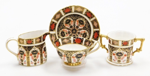 A collection of Royal Crown Derby porcelain Imari pattern items, to include a loving cup, 7.5cm high, milk jug, 8cm high, and a teacup and saucer, each with red stamp to underside, second.