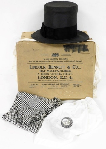 An early 20thC Welsh hat by A. Spurling, with interior with a hand sewn label for Ludbury, a small white cotton apron, with handwritten name label for E. M Ludbury, and a gingham shawl, contained in a Lincoln, Bennett & Co London hat box.