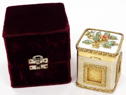 A Continental gilt coloured and metal lidded box, of rectangular form, the hinged lid raised with flowers, with a front elaborate cartouche, in a velvet finish box, unmarked, the jar 8cm high.