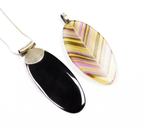 Two large drop pendants, with white metal mounts and chains, marked 925, one with black polished stone and the other with glitter lined detailing. (2)