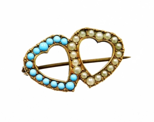 A twin heart brooch, set with imitation turquoise and seed pearl in copper backing, on single pin back, 2.5cm wide.