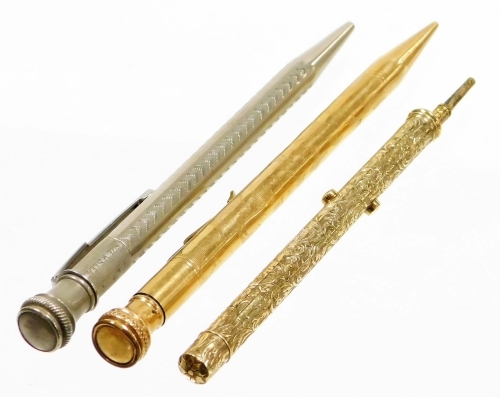 Three pencils, a gold plated pencil, bearing the initials ENW, a yellow metal pencil case with floral embossed detailing bearing the initials AHW Brett November 1880, unmarked, and a silver plated pencil size V. (3)