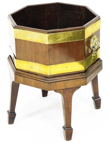 An early 19thC mahogany and brass bound wine cooler, of octagonal form, with a galvanised tin, lion mask handles, and square legs terminating in spade feet, 55cm high, 46cm wide, 40cm deep.