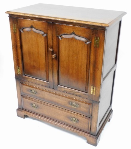 A Titchmarsh and Goodwin oak television cabinet, with two cupboard door top above two long drawers, 113cm high, 93cm wide, 51cm deep.