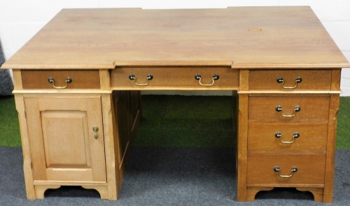 An oak partner's or office desk, of rectangular form, inverted moulded top raised above six frieze drawers, on twin pedestal base, with swan necked handles, 81cm high, 171cm wide, 131cm deep.