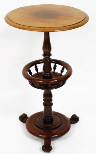 A 20thC mahogany finish stand, the circular top raised above baluster column, with central section on circular foot, terminating in triple scroll feet, 71cm high, 40cm diameter.
