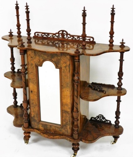 A Victorian walnut display cabinet, with pierced cornice raised above a glazed panel door flanked by open shelves, with turned columns terminating in pot castors, 93cm high, 112cm wide, 34cm deep.