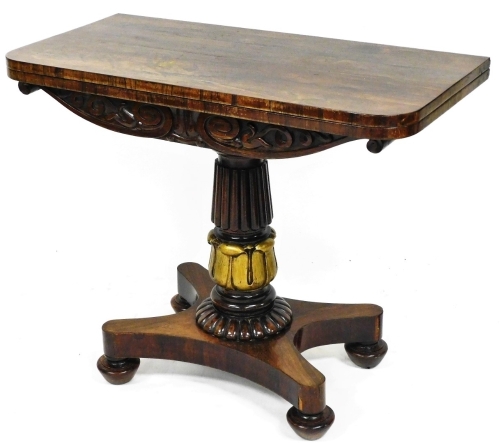 A Regency rosewood fold over card table, on a heavy reeded acanthus leaf stem, terminating in an inverted platform base, on compressed bun feet, when closed 76cm high, 91cm wide, 45cm deep.