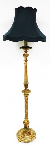 A heavily carved giltwood lamp standard, with turquoise shade on turned stem and circular base, terminating in compressed bun feet, 189cm high.