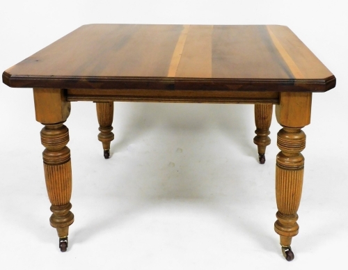An early Edwardian walnut extending dining table, the canted top raised on heavy reeded tapering legs, terminating in castors, 72cm high, 105cm wide, 102cm deep.