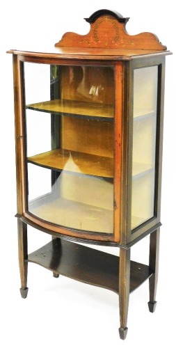An Edwardian mahogany bow front display cabinet, on square tapering legs terminating in spade feet, 142cm high, 65cm wide, 40cm deep.