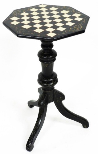 A 20thC painted games table, the octagonal top with chequer board decoration, on heavy turned stem with a tripod base, 70cm high, 38cm wide, 38cm deep.