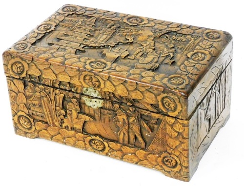 A heavily carved Oriental design box, profusely decorated with buildings, figures, and trees, with a leaf and flower head border, and elaborate escutcheon, with plain interior, 23cm high, 45cm wide, 26cm deep.