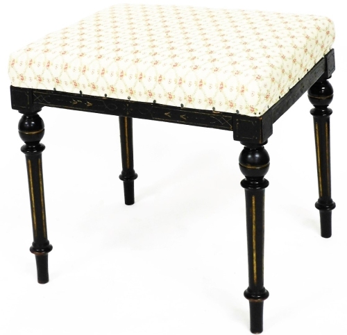 An Edwardian ebonised stool, the padded seat with floral diamond decoration, on turned reeded legs, 45cm high, 46cm wide, 38cm deep.