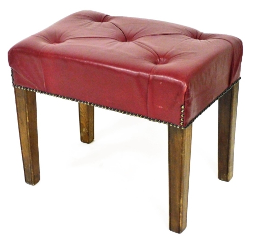 An early 20thC oak stool, of rectangular form, with studded over stuffed red leatherette top, on square tapering legs, 46cm high, 53cm wide, 36cm deep.