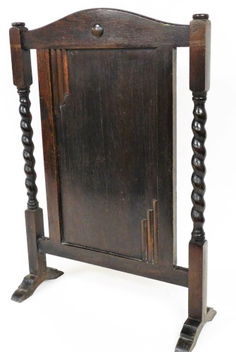 An Art Deco style oak firescreen, with barley twist sides, on stepped scroll feet, 72cm high.