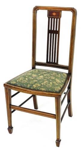 An Edwardian mahogany occasional chair, with shaped cresting rail, above a pierced back splat and padded seat, in floral material, raised on square tapering front legs, terminating in spade feet.