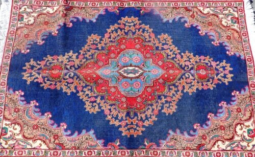 A Persian carpet, on blue ground, overfilled with medallion design, 230cm x 146cm.