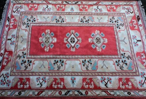 A Shiraz red ground rug, decorated with three central gulls, in repeating floral borders, 264cm x 198cm.