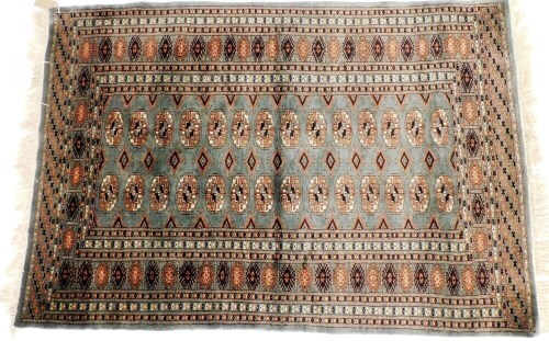 A Tekke turquoise ground rug, decorated with two rows of fourteen guls, within repeating geometric borders, 144cm x 97cm.
