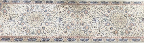 A Super Keshan runner, cream ground, decorated with two central and two half floral medallions, repeating foliate and floral motifs, within a geometric border, 348cm x 90cm.