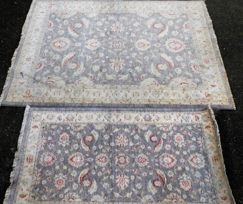 A pair of graduated Belgium Kabir Goby wool rugs, floral decorated brown ground, 190cm x 140cm, smaller rug 155cm x 85cm.