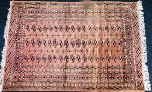 A Tekke red ground rug, decorated with three rows of seventeen guls, within repeating geometric borders, 183cm x 125cm.