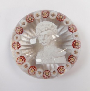A 19thC Continental sulphide and millefiori glass paperweight, decorated with the bust portrait of a Russian Emperor, possibly Nicholas I, within alternating red and white millefioris, on a star cut base, 7cm diameter. (AF) - 3